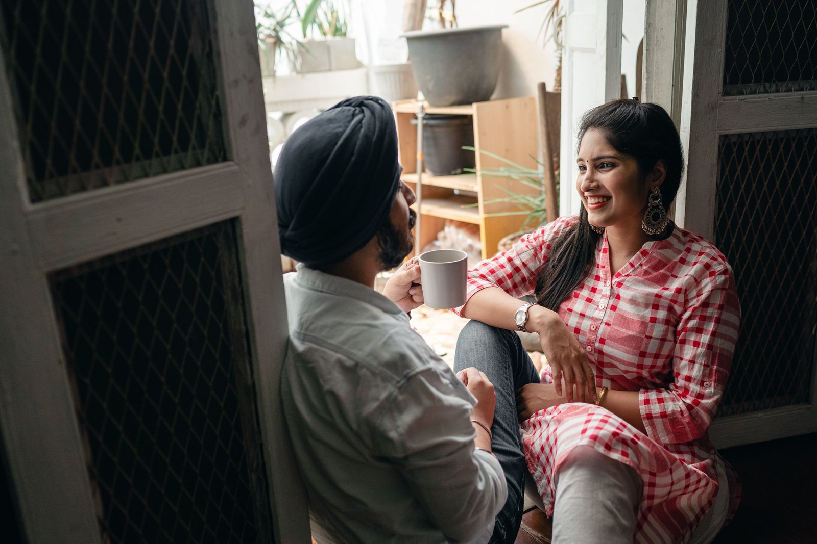 An Indian couple talking together over coffee at home